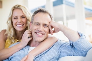 couple smiling while relaxing on a couch