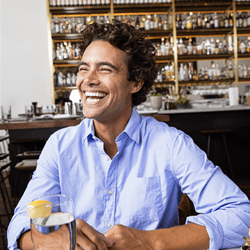 man smiling and laughing in a restaurant setting